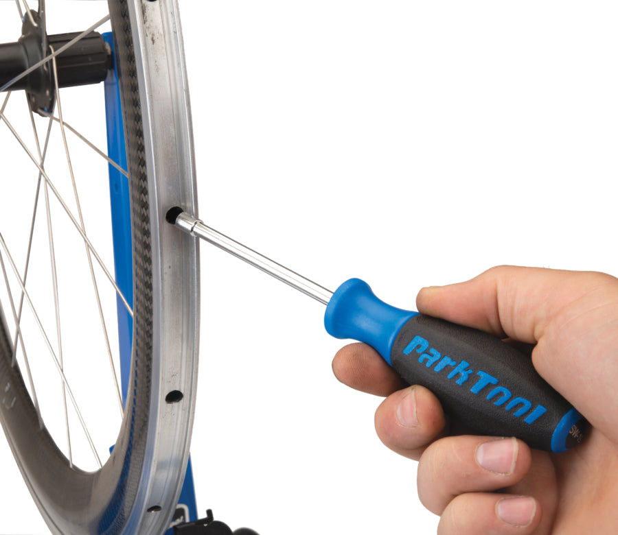 Park Tool SW-19 in een velg gestoken om een interne spaaknippel te bereiken