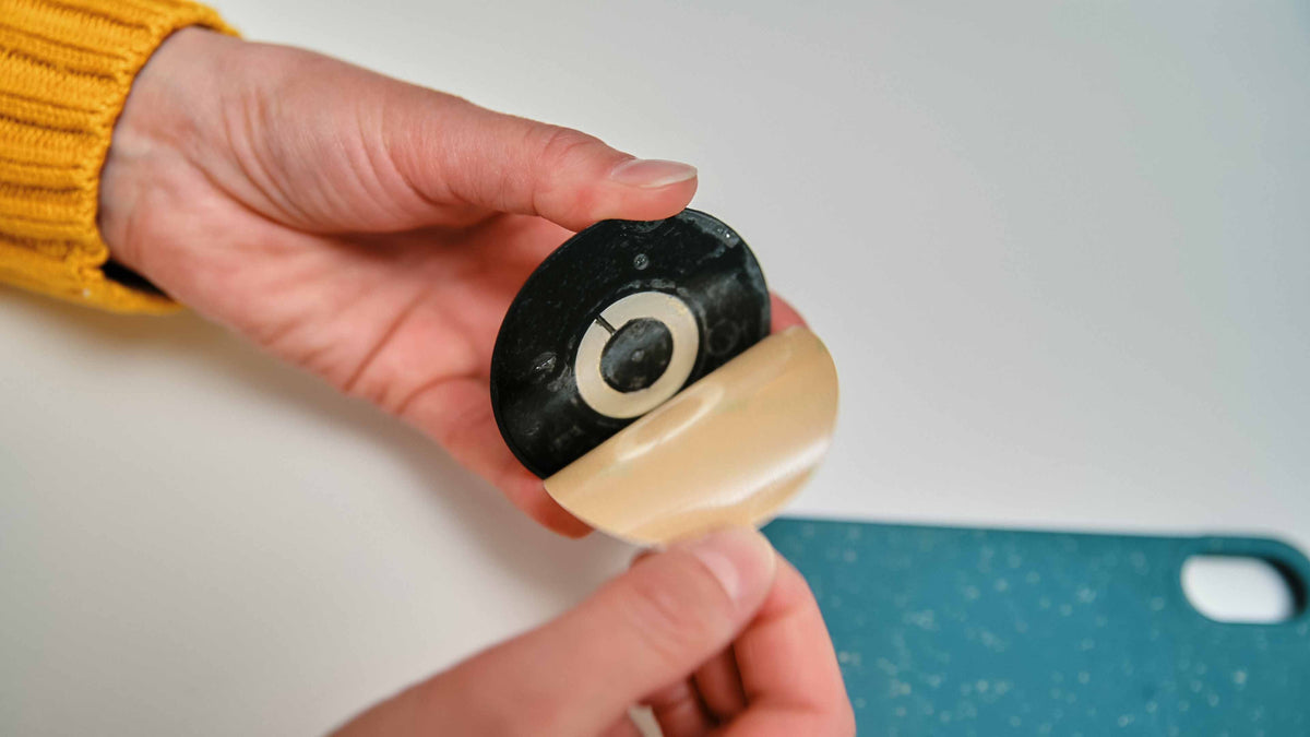 Zwarte FIDLOCK VACUUM-patch voor universeel gebruik met smartphones — verwijderen van de beschermfolie vóór het aanbrengen van de zwarte patch
